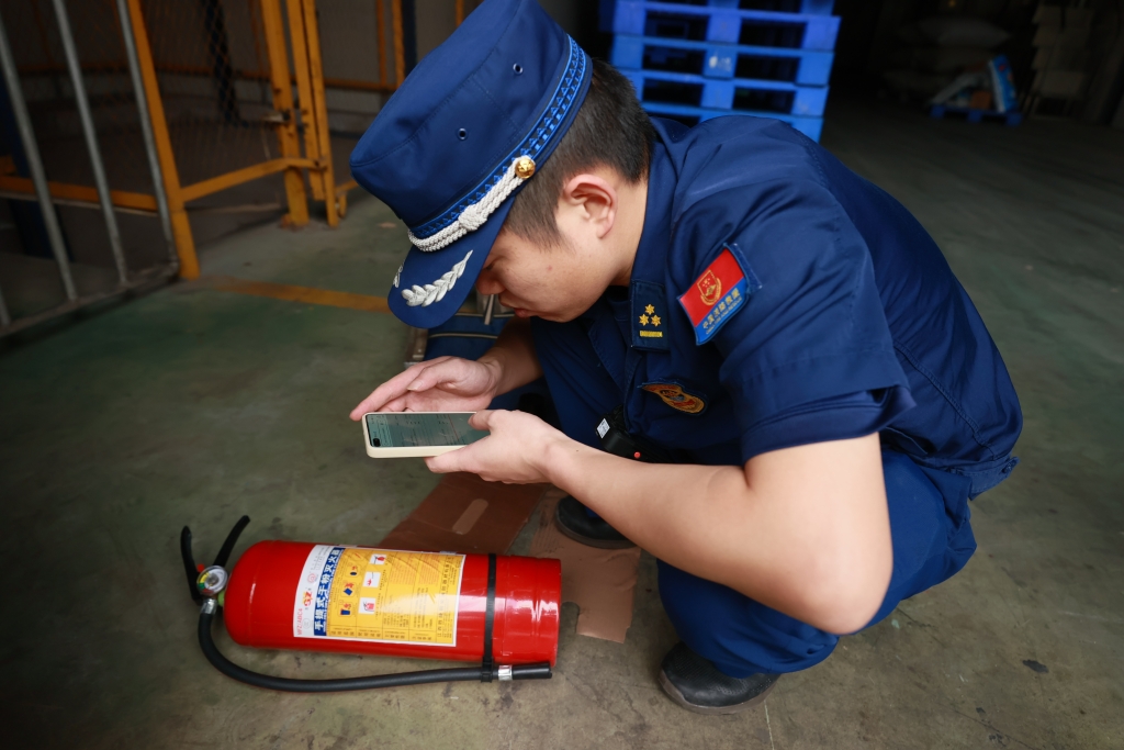 江津区消防员对灭火器的真伪进行鉴别。受访单位供图
