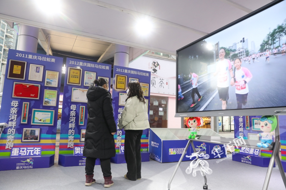 市民在重庆马拉松展台前了解这项重庆的体育赛事。华龙网-新重庆客户端记者 张质 摄 