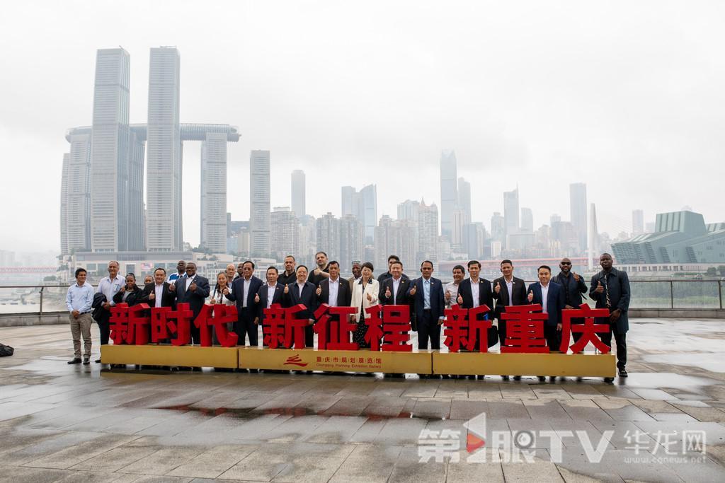 参加“2026重庆国际友好城市合作大会”的嘉宾们来到重庆市规划展览馆参观，在江边合影留念。第1眼TV-华龙网记者 石涛 摄